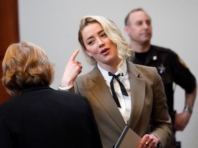 Actor Amber Heard talks to her attorney  Elaine Bredehoft during her ex-husband Johnny Depp's defamation case against her, at the Fairfax County Circuit Courthouse in Fairfax, Virginia, U.S., May 23, 2022.