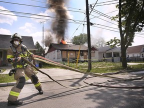 Be prepared for emergencies, like house fires. In this May 7, 2021, file photo, a Windsor firefighter stretches a hose at the scene of an abandoned house fire in the 3500 block of Peter Street.