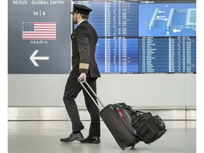 A pilot arrives at the United States check-in area at Toronto Pearson Airport during concerns the Covid 19 virus, Friday March 13, 2020.