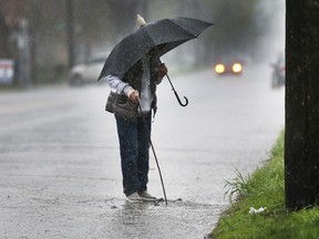 An Environment Canada special weather statement wasn't enough to scare Windsor's Joyce Boismier away from venturing outdoors to clear debris from a storm drain along Sandwich Street during a heavy downpour on Tuesday, May 3, 2022. Wednesday has a sunny afternoon forecast with a high of 16 C.