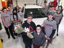 Melissa Luce und ihr Sohn Eric, 8, posieren am Mittwoch, den 18. Mai 2022, mit Schülern der EJ Lajeunesse High School. Die Schüler präsentierten Luce ein Fahrzeug, das sie im Rahmen des Rebuilding Wheels Rebuilding Lives-Programms repariert hatten.
