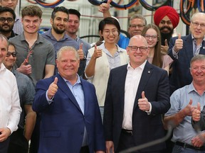 Premier Doug Ford, front, second from left, and Windsor Mayor Drew Dilkens pose for photos with Valiant TMS employees in Windsor on Friday, May 13, 2022.