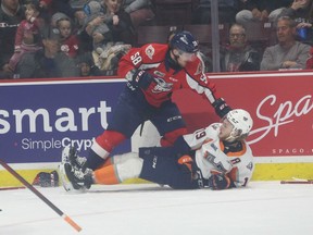 Windsor Spitfires defenceman Andrew Perrott readies a punch with Flint Firebirds' forward Riley Piercey during Monday's playoff game at the WFCU Centre.