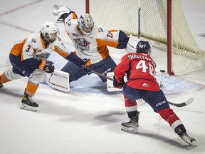Alex Christoplouos scores a first-period goal against Flint firebirds' Luke Cavallint during Sunday's game at the WFCU Centre.