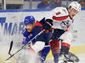 Kitchener Rangers' forward Navrin Mutter is taken out by Windsor Spitfires' defenceman Nathan Ribau during Tuesday game at the Kitchener Memorial Auditorium. David Bebee/Waterloo Region Record.