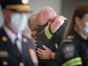 Essex-Windsor EMS-Mitglied Nicole Hanson umarmt Dan Robinson, dessen Frau von Sanitätern gerettet wurde.  Fotografiert bei der 9. jährlichen Feier zum Tag der Überlebenden in Windsor am 27. Mai 2022.
