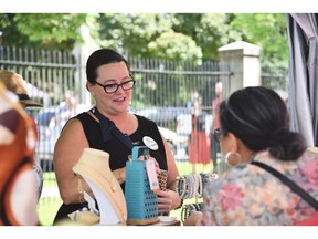 Windsors Heidi Steinhoff, die den Gästen von The Beadiva bekannt ist, hilft einem Kunden bei Art in the Park im Willistead Park am Samstag, den 4. Juni 2022.