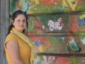 Artist Christine Paris, pictured with one of the murals she painted in Butterfly Lane. The murals were unveiled last fall, and the official name of the laneway was unveiled on on Saturday, June 4, 2022.