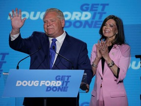 Ontario Premier Doug Ford, accompanied by his wife Karla, waves from the podium during his Ontario PC Party provincial election night watch party at the Toronto Congress Centre in Etobicoke, Ontario, Canada June 2, 2022. REUTERS/Chris Helgren