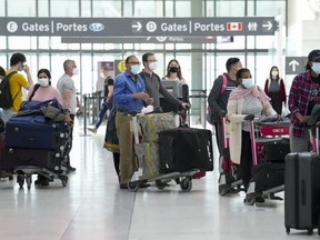People wait in line to check in at Pearson International Airport in Toronto, May 12, 2022.