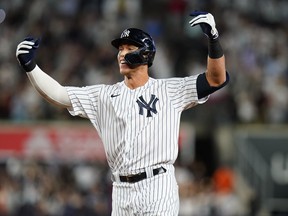 New York Yankees' Aaron Judge gestures to teammates after hitting a single to drive in the winning run during the ninth inning of the team's baseball game against the Houston Astros on Thursday, June 23, 2022, in New York.