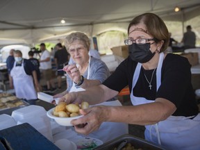 Opa! Volunteers serve up a bowl of honey balls on the first day of the Greek village during Carrousel of Nations, on Friday, June 17, 2022.