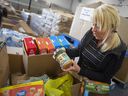 'Anyone can donate anytime.' June Muir, president of the Windsor-Essex Food Bank Association, goes through donations made to the Miracle food drive on Monday, June 27, 2022.