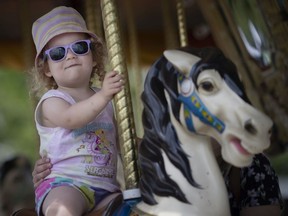 Audrey Epp, 2, rides the Merry Go Round with her aunt, Lauren Gillespie, while at the Leamington Fair, on Friday, June 10, 2022.
