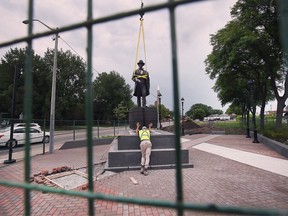 Ein Arbeiter führt am Montag, den 20. Juni 2022, eine Bronzestatue von Hiram Walker an der Ecke Riverside Drive und Devonshire Road.