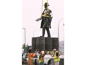 Arbeiter installieren am Montag, den 20. Juni 2022, eine Bronzestatue von Hiram Walker an der Ecke Riverside Drive und Devonshire Road.