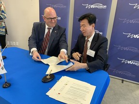 Windsor Mayor Drew Dilkens and DongShin Motech CEO Choon Woo Lim sign letters of intent on Friday following the announcement that the South Korean company will spend at least $60 million to build a new facility to supply parts to the upcoming Stellantis/LG Energy Solutions EV battery plant.