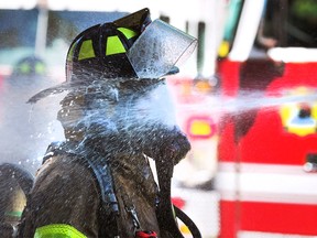 A Windsor firefighter gets debris rinsed off at a house fire on Janette Avenue in Windsor on Friday, June 24, 2022.