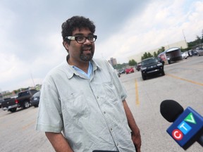 Chris Ramsaroop, organizer for Justicia for Migrant Workers, tells members of the media about a caravan gathered in a Leamington parking lot seeking protections and better conditions for temporary foreign workers on Sunday, June 12, 2022.