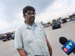 Chris Ramsaroop, un organisateur de Justicia for Migrant Workers, parle aux membres des médias d'une caravane rassemblée dans un parking de Leamington à la recherche de protections et de meilleures conditions pour les travailleurs étrangers temporaires le dimanche 12 juin 2022.