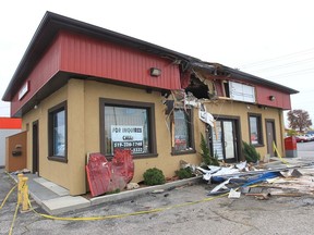 A gaping second-storey hole is seen on a commercial building in the 200 block of Talbot Street West in Leamington on Oct. 13, 2012. Two men were taken to hospital with life-threatening injuries after the truck they were travelling in launched into the air and struck the building shortly before 2 a.m. the night before. DAN JANISSE FILE