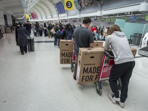 Travellers wait in the queue at Toronto Pearson Airport’s Terminal 3, Thursday May 9, 2022.