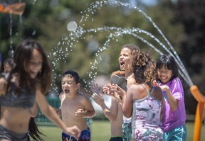 Students from W.J. Langlois and William G. Davis elementary schools enjoy the newly installed splash pad at Fountainebleau Park on Friday.