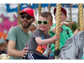 Derek Bellemore and son Cole, age three, ride the carousel at the LaSalle Strawberry Festival on Sunday, June 12, 2022.