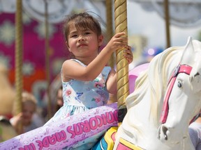 Alicia, age three, rides the carousel at the LaSalle Strawberry Festival on Sunday, June 12, 2022.