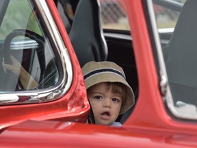Young car enthusiast Sonny Suntres, 2, peeks out from an entrant in the Hot Wheels Legends Tour stop in Windsor on July 16, 2022.