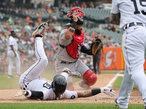 Javier Baez of the Detroit Tigers slides into home plate past Sandy Leon of the Cleveland Guardians to score a fifth inning run at Comerica Park on July 06, 2022 in Detroit, Michigan.