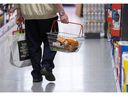 Un client transporte un panier de produits alimentaires dans un supermarché Iceland Foods Ltd. à Christchurch, au Royaume-Uni, le mercredi 15 juin 2022.