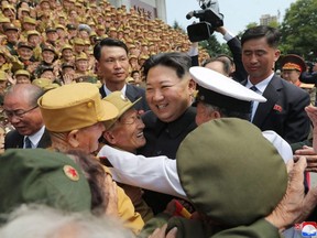 This picture taken Thursday, July 28, 2022 and released by North Korea's official Korean Central News Agency (KCNA) on Friday, July 29, 2022 shows North Korean leader Kim Jong Un (centre) taking pictures with participants in the 8th National Conference of War Veterans at the Monument to the Victorious Fatherland Liberation War in Pyongyang.