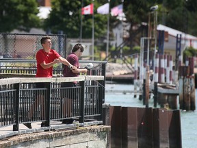 Two young men fish from the King's Navy Yard Park in Amherstburg on Monday, July 25, 2022, next to the fenced-off from Duffy's marina property. Town council on Monday rejected a proposal that would have seen work proceed sooner to extend public access along the park's riverfront further south.