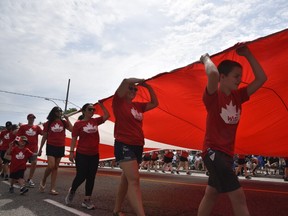 Qu'est-ce qu'un défilé de la fête du Canada sans un drapeau canadien de taille canadienne. Celui-ci a été tenu en l'air par une équipe de la WFCU Credit Union le long du parcours du défilé qui longeait Wyandotte Street East de Devonshire à Aylmer.