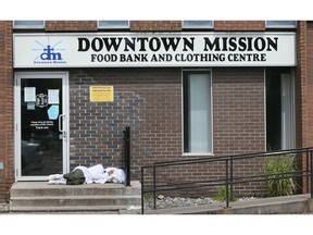 A homeless person sleeps on the steps of the Downtown Mission on Ouellette Avenue on Wednesday, July 28, 2022.