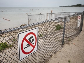 A 'No Swimming' sign and fencing is seen on the western portion of Sand Point Beach in Windsor where several drownings have occurred, the most recent a year ago.  (DAX MELMER/Postmedia Network)