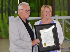 Windsor Ward 10 Coun. Jim Morrison, left, presents the city's proclamation of July 3, 2022, as 'Father Paul Carbonneau Day' to Brentwood Recovery Home executive director Elizabeth Dulmage on Thursday, July 7, 2022.
