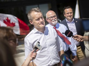 Federal Minister of Labour Seamus O'Regan is joined by Tecumseh Mayor Gary McNamara, and Windsor-Tecumseh MP Irek Kusmierczyk during a vehicle charging infrastructure announcement outside Tecumseh town hall, on Monday, July 11, 2022.