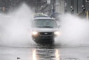 A motorist plows through a flooded section of Howard Avenue near Tecumseh Road in Windsor on Jan. 11, 2020.