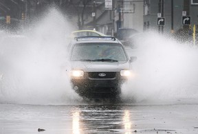 Un automobiliste traverse une section inondée de l'avenue Howard près du chemin Tecumseh à Windsor le 11 janvier 2020.