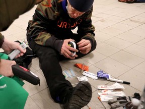 A homeless man is shown the contents of a naloxone kit in Edmonton in February 2022.