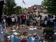 Mourners visit a memorial site after a mass shooting at a Fourth of July parade in the Chicago suburb of Highland Park, Ill., Wednesday, July 6, 2022.