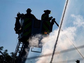 Firefighters on an aerial platform direct water onto a building at 495 Tuscarora St. in Windsor on July 14, 2022.