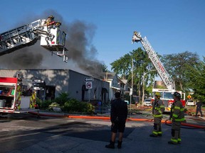 Firefighting aerial platforms direct water onto a multi-unit building at 495 Tuscarora St. in Windsor on July 14, 2022.