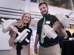University of Windsor engineering students Christine Denotter and Matt Rac-Sabo show off their flagship dumbbell project made with recycled materials - part of the exhibits at the Ed Lumley Center for Engineering Innovation on July 29, 2022.
