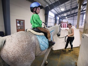 Sawyer Shepley, 4, rides a horse at the Windsor-Essex Therapeutic Riding Association in Essex on Wednesday, July 6, 2022 under the watchful eye of leader Samantha Kolody.