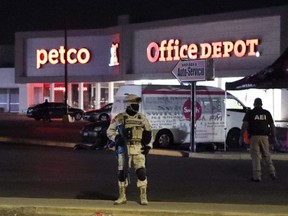 Members of the Mexican Army and forensic experts work at the site where four radio station workers were killed and two restaurant employees were wounded in Ciudad Juarez, Mexico, Thursday, Aug. 11, 2022.