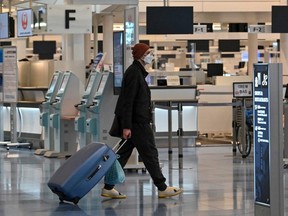 A man walks past check-in counters at an international flight departure floor at Tokyo's Haneda Airport, Dec. 1, 2021.