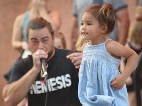 Human beatbox Scott Jackson performs with the help of a young audience member at Busk On the Block in Windsor's Walkerville area on Aug. 6, 2022.